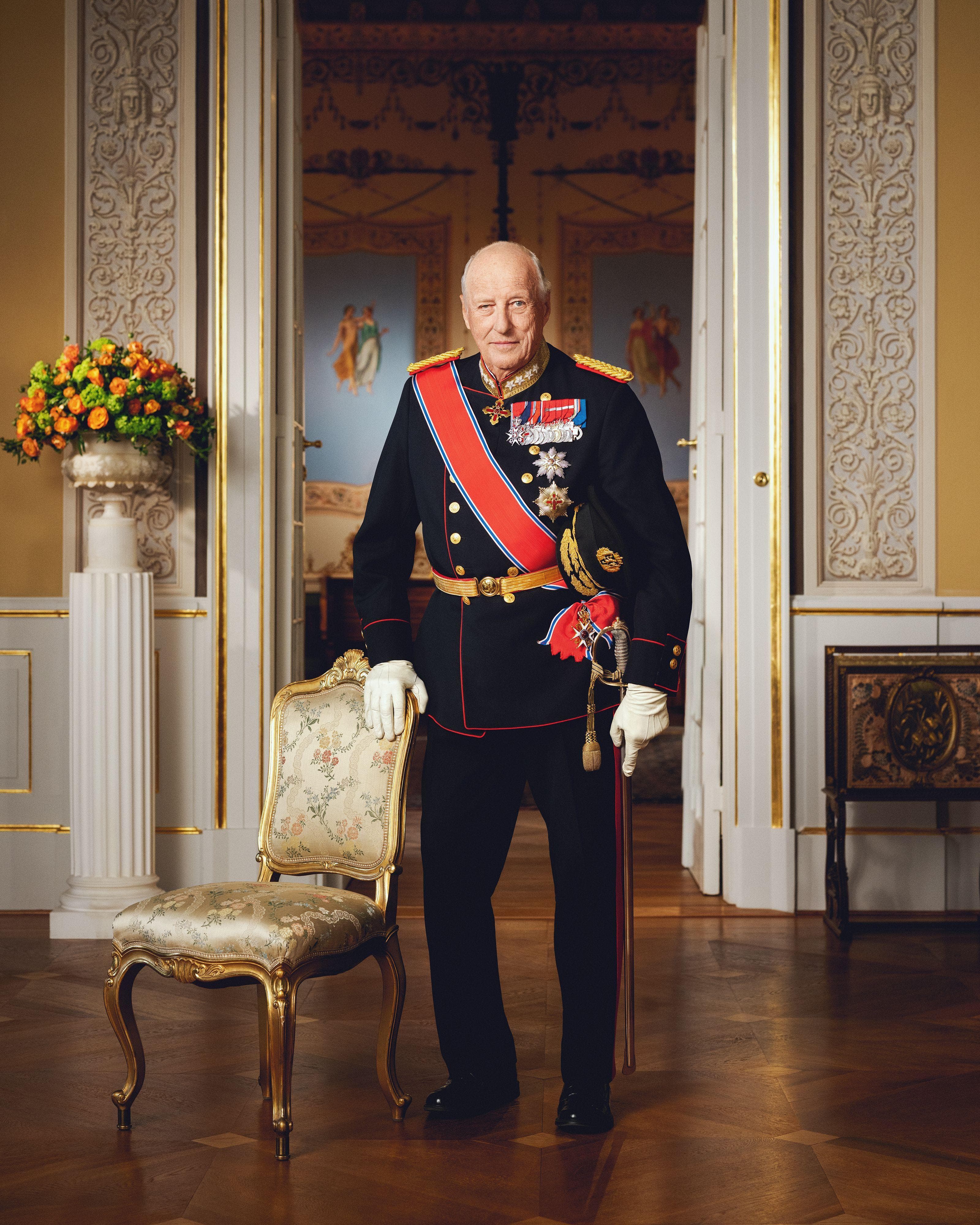 Kong Harald V stående i gallauniform på Det kongelige slott.